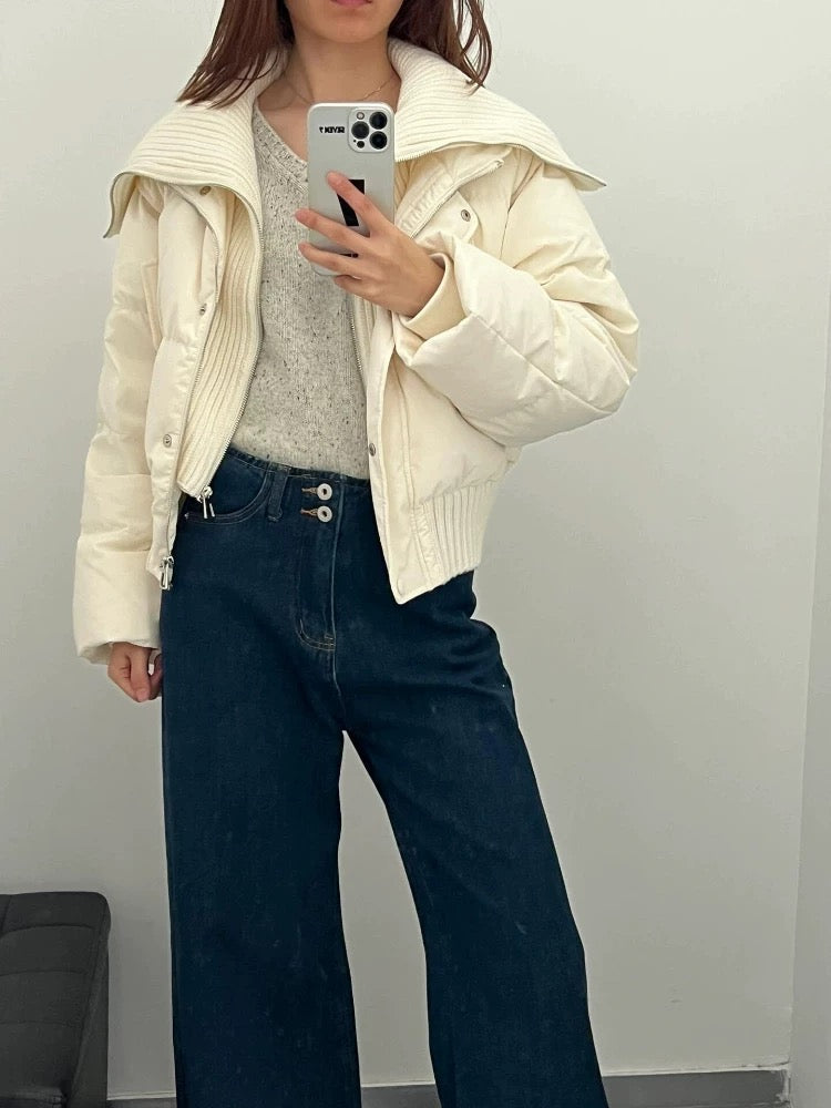 Frau in beiger Pufferjacke mit hohem Kragen und Reißverschluss