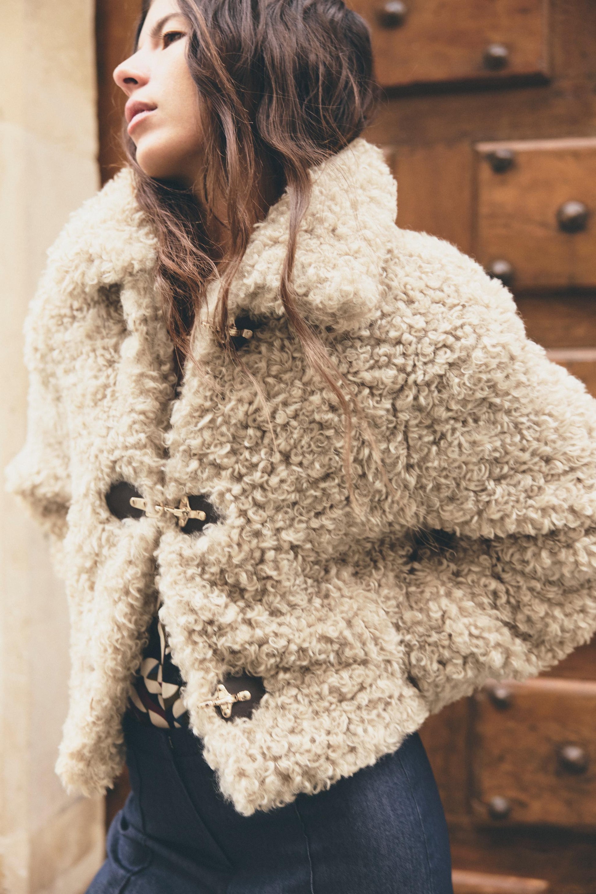 Detailansicht der beigen Teddyjacke mit flauschiger Struktur
