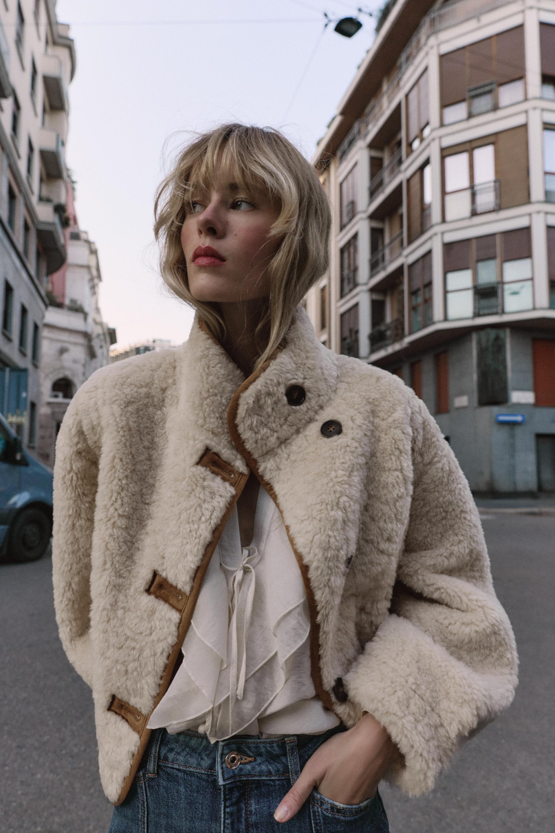 frau trägt beige teddyjacke mit knöpfen auf der straße
