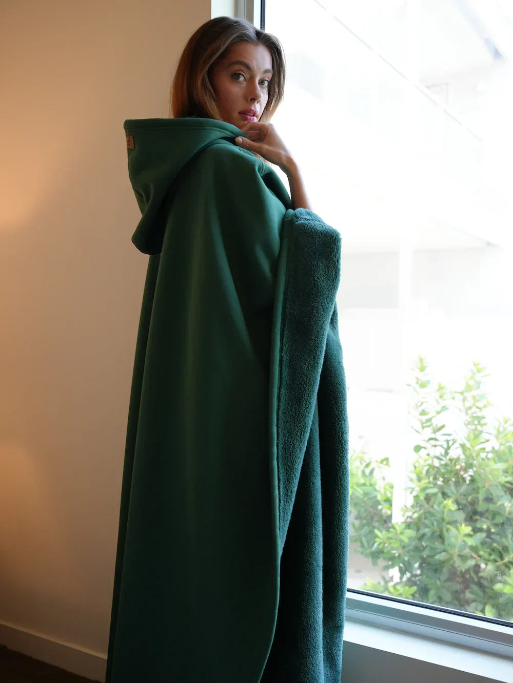 Eden Hoodie Blanket in Dunkelgrün gemütlich getragen
