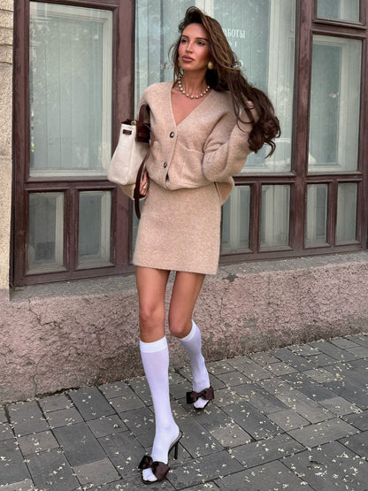 frau trägt beiges strick set mit weißen kniestrümpfen und schleifen high heels