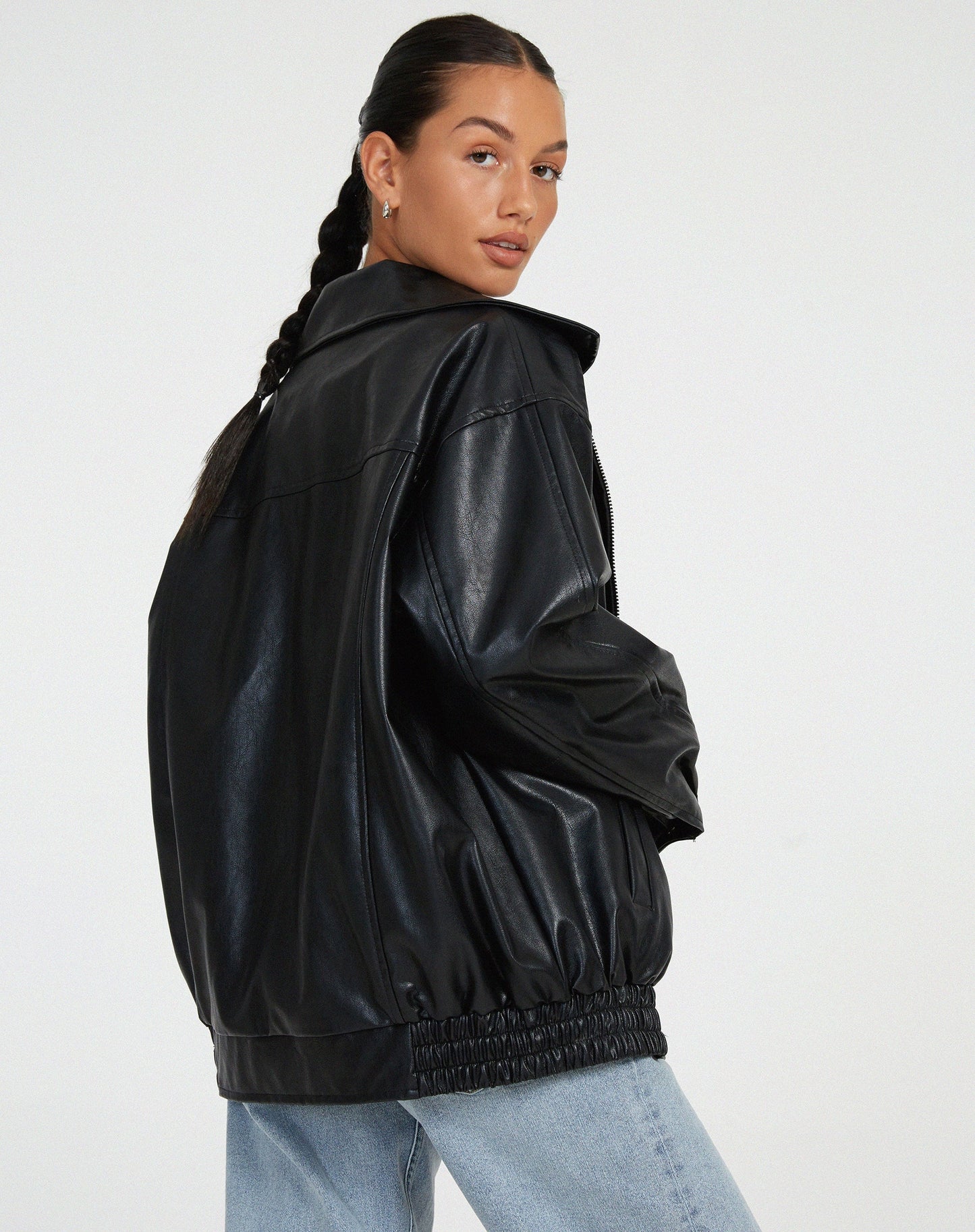 schwarze oversized Lederjacke kombiniert mit weißem Crop-Top und Mom-Jeans
