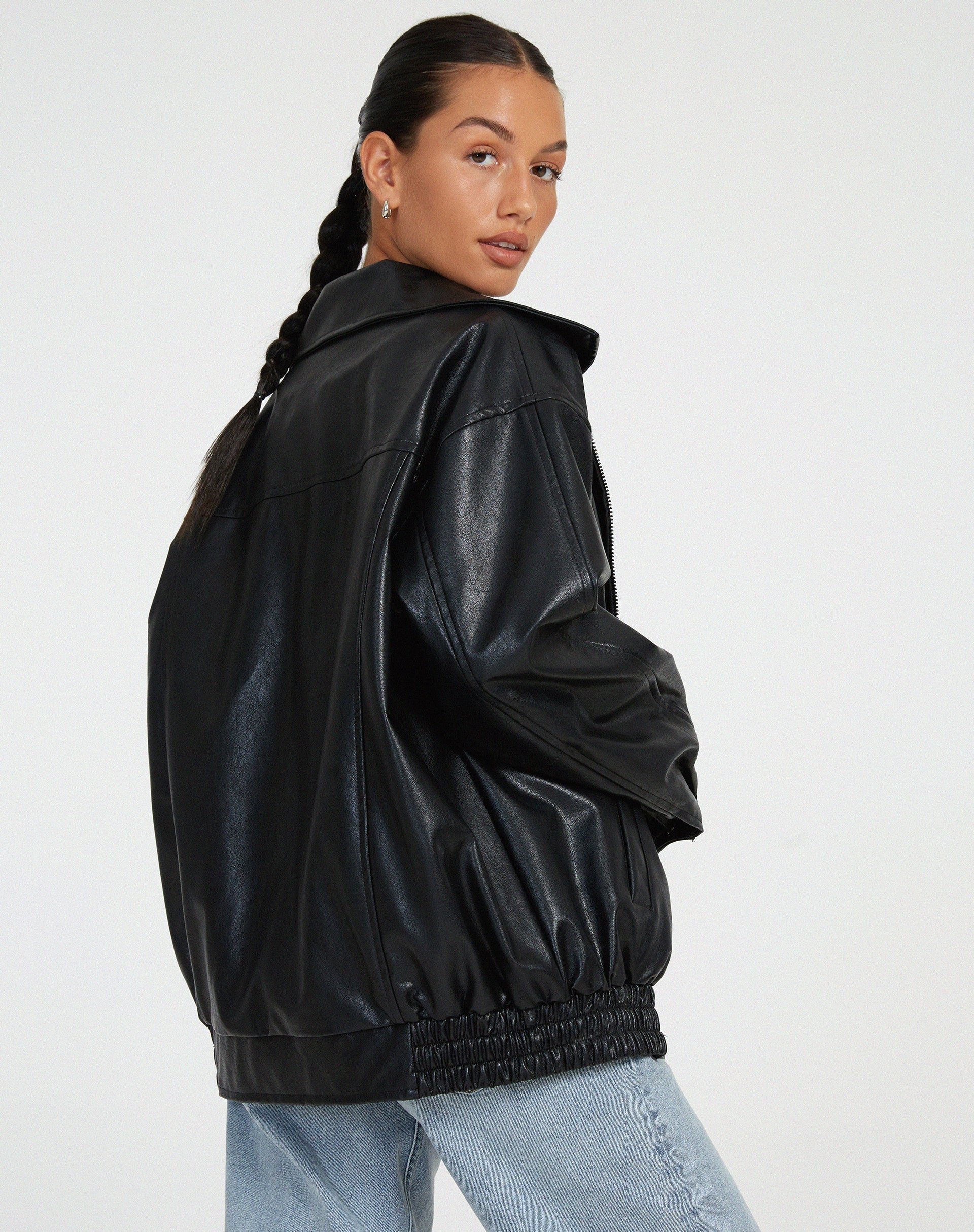 schwarze oversized Lederjacke kombiniert mit weißem Crop-Top und Mom-Jeans