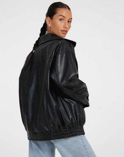 schwarze oversized Lederjacke kombiniert mit weißem Crop-Top und Mom-Jeans
