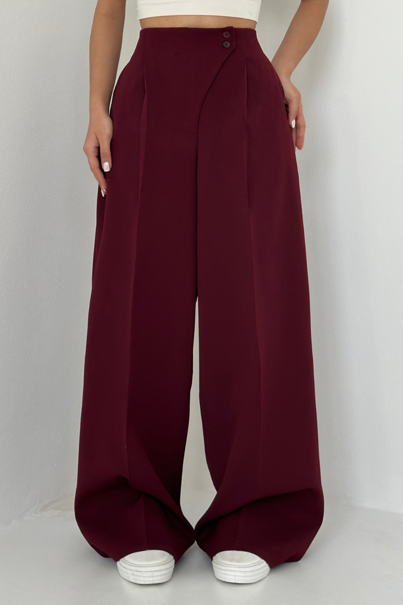 nahaufnahme bordeauxrote hose mit asymmetrischem Knopfverschluss