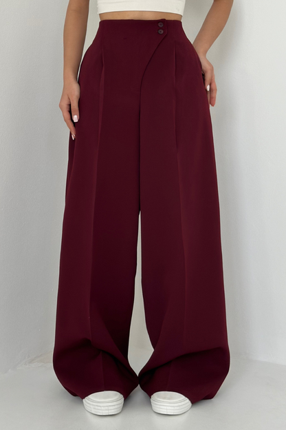 nahaufnahme bordeauxrote hose mit asymmetrischem Knopfverschluss