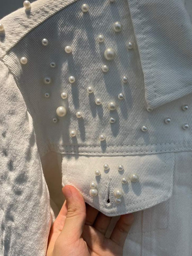 Nahaufnahme des Produkts, das die Details der Jacke zeigt und die weiße Perlenverzierung hervorhebt