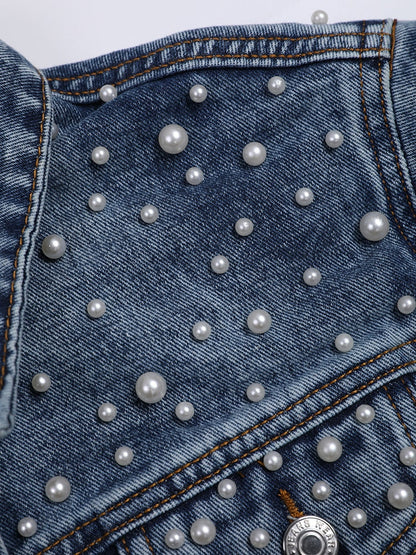 Nahaufnahme, die das Detail einer Jeansjacke mit weißer Perlenverzierung zeigt