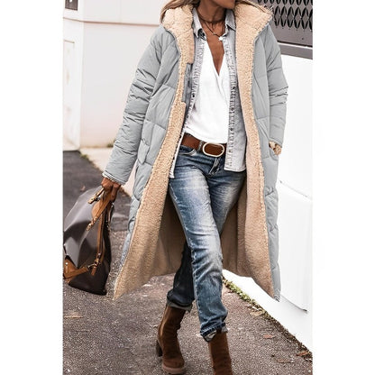 Eine frau in einem langer, bequemer grau mantel und jeans