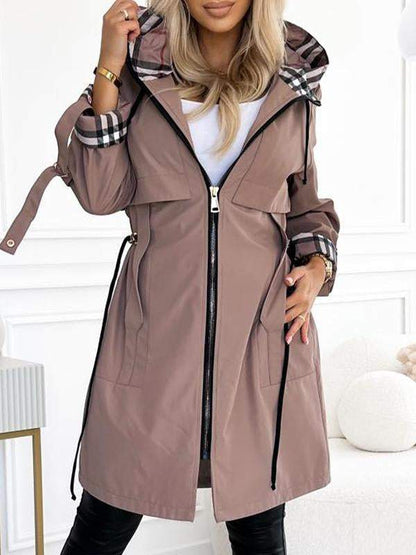 Khaki Trenchcoat mit Kapuze und Karodetail, offen getragen.
